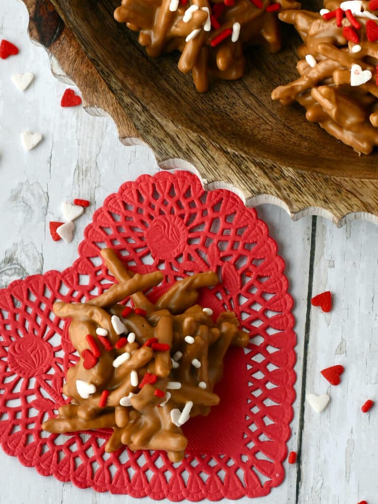 Cookie Butter Haystacks with heart valentine sprinkles on a red heart doilie.