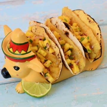 Image of fish tacos in a taco holder designed like a cow with a sombrero.