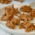 Cookie butter haystacks candy with cashews on Christmas round white plate.