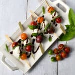 Top down view of tomato mozzarella basil skewers with balsamic glaze drizzle.