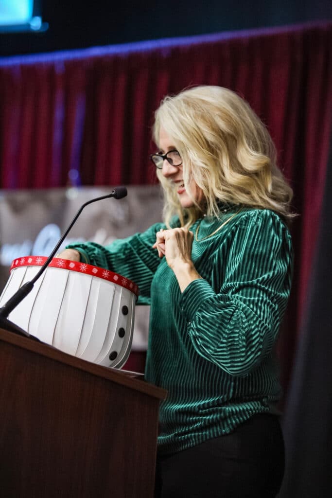 woman pulling ticket out of a snowman basket. kathy
