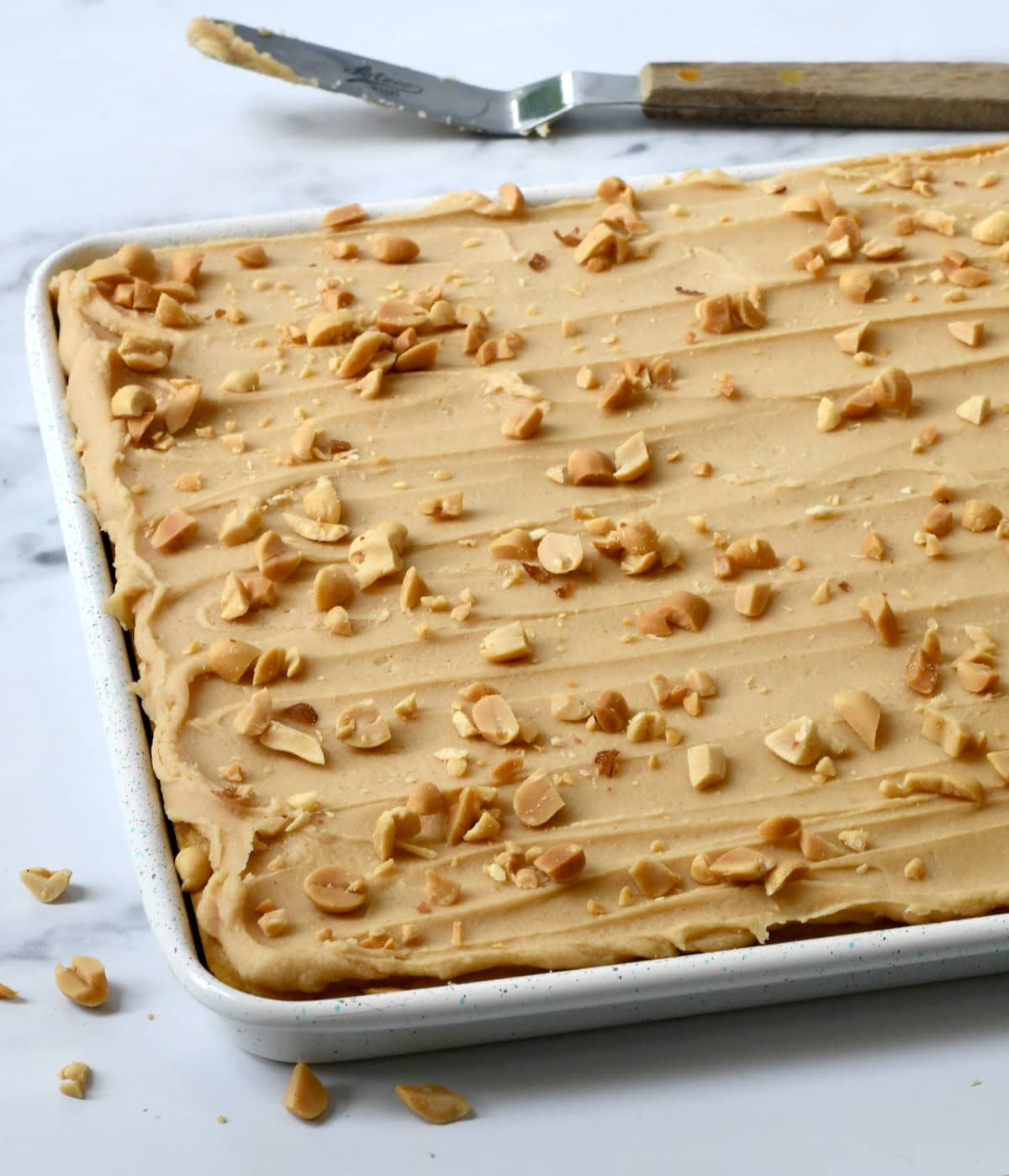 Peanut Butter Sheet Cake with cake mix in pan with frosting spreader.