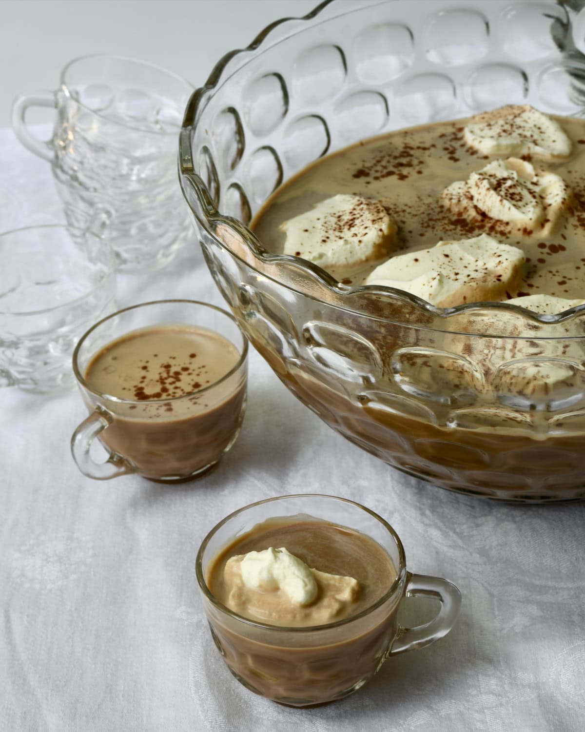 Mocha iced coffee punch in punch bowl and with whipped cream in punch cups. 
