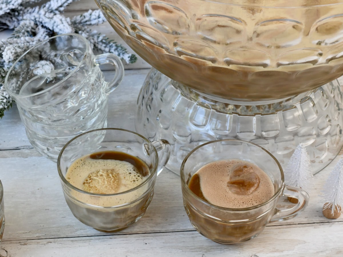 Two glass cups filled with creamy coffee punch, each topped with a scoop of melting ice cream