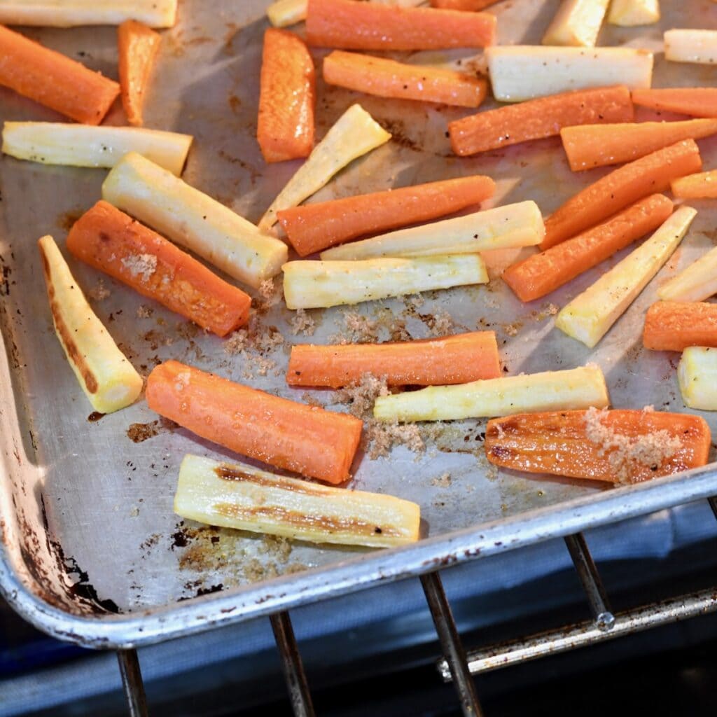 Roasted carrots and parsnips on a metal baking sheet