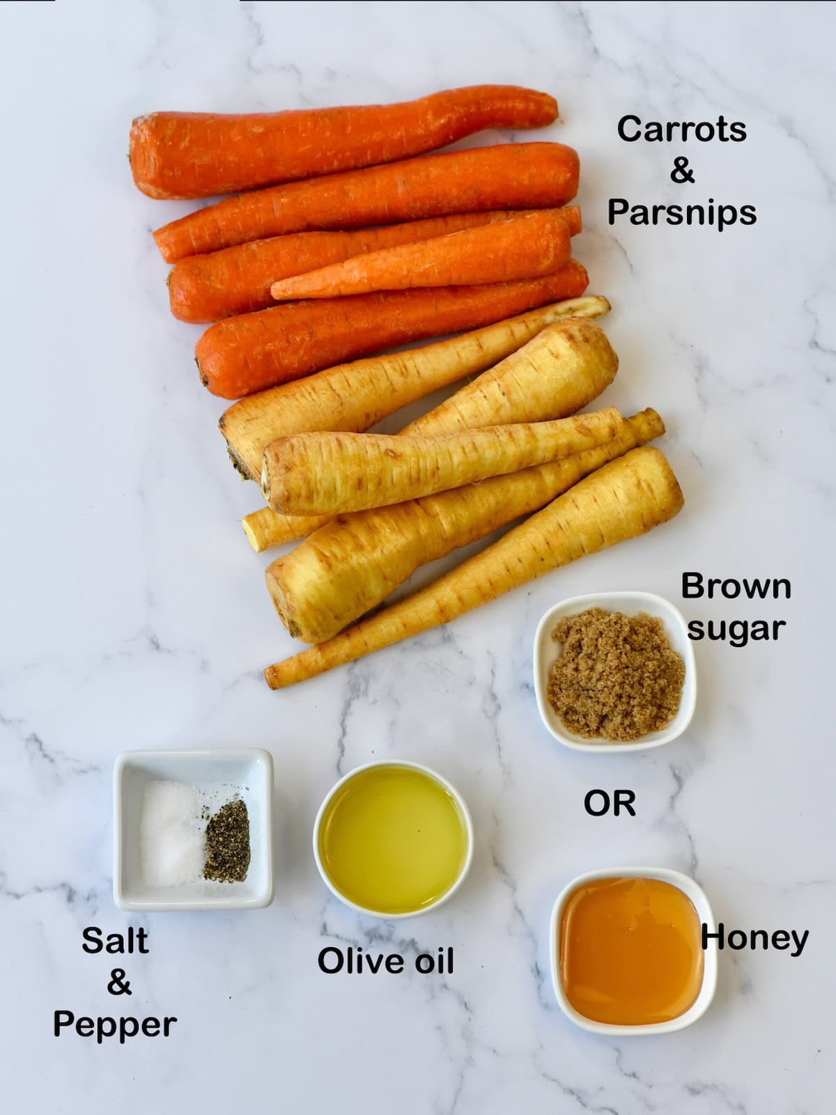 Ingredients for roasted parsnips and carrots laid out on a marble surface