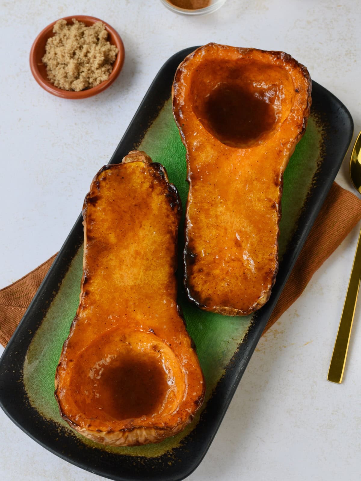 Two air fried butternut squash halves on a green serving tray