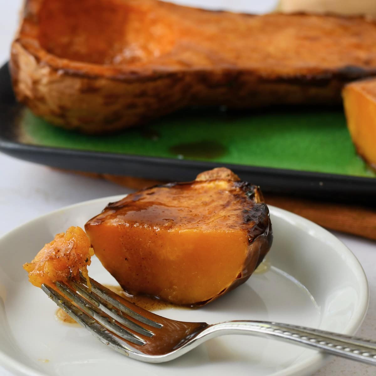 Air fried butternut squash half served on a small plate with a fork