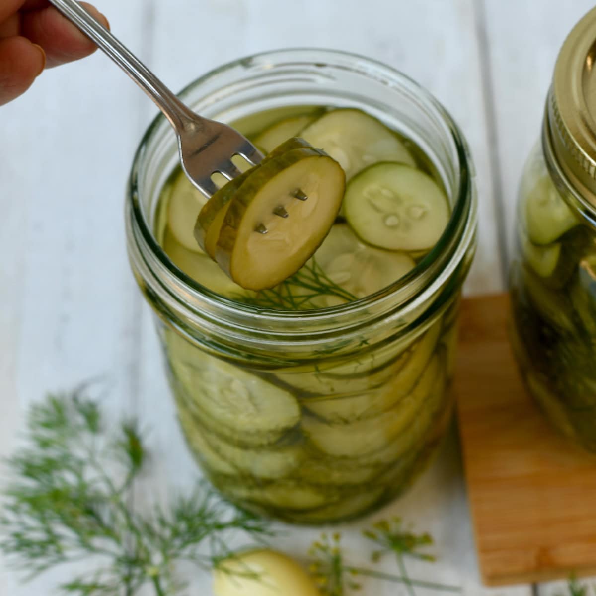 Easy dill pickle chips in a jar with a fork stuck in the pickles.