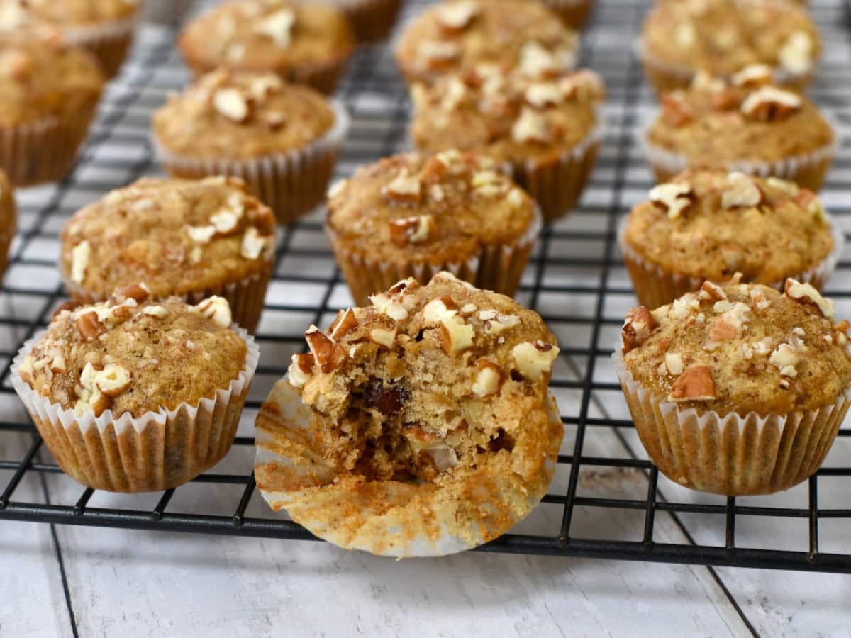 Banana Nut Bread mini muffins on cooling rack with a bite taken out of one.

