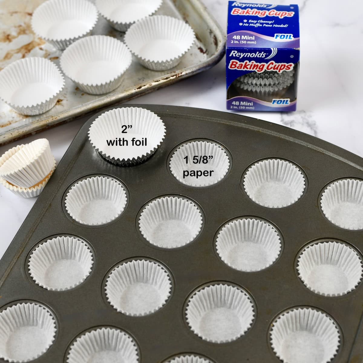 Two different sizes mini muffin paper liners in muffin tins.
