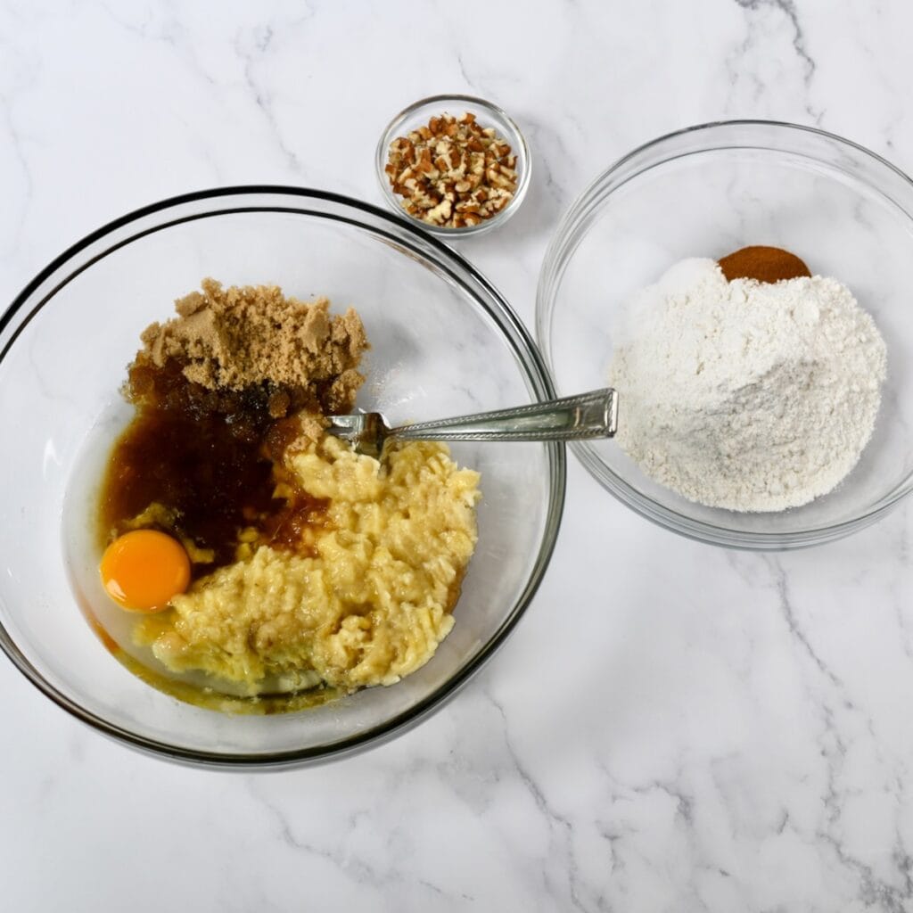 Mashed banana, brown sugar and egg in one bowl with flour and cinnamon in another bowl.