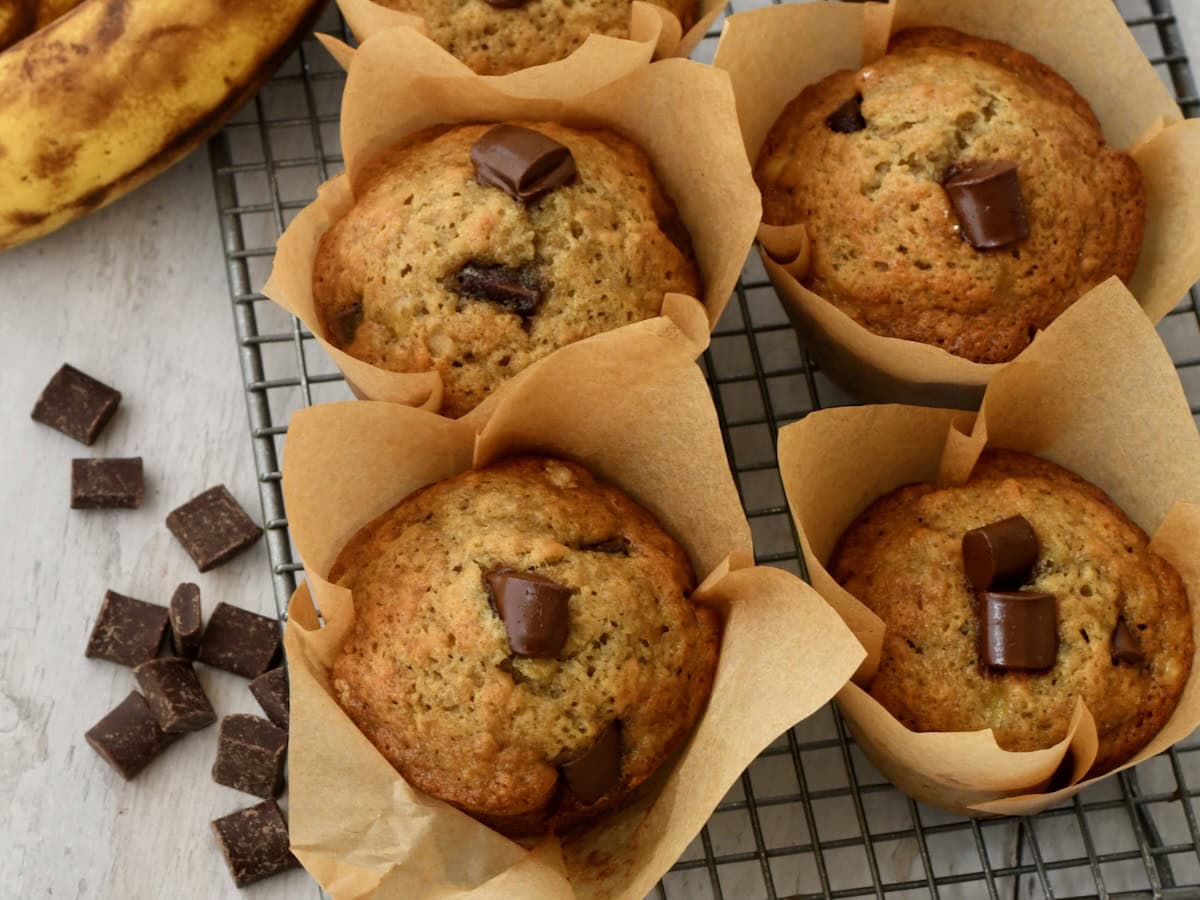 chocolate chunk banana bread muffins in brown parchment liners.