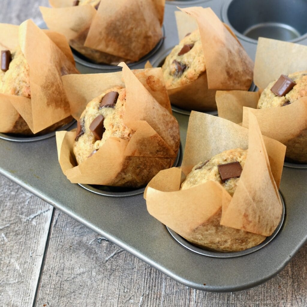 chocolate chunk banana muffins tilted in muffin pan to cool.
