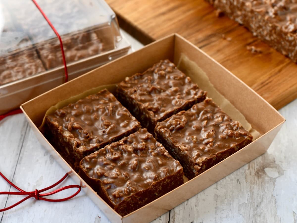 chocolate peanut butter rice crispy treats in food gift containers with red ribbon.