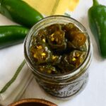 An open jar of cowboy candy candied jalapenos.