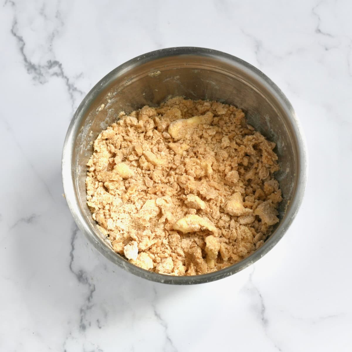 Butter crumbled with flour mixture for peach crumble topping.