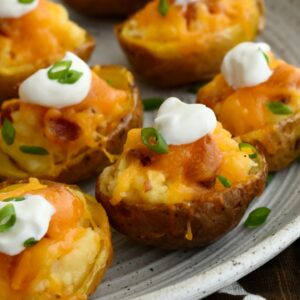 Mini twice baked potatoes on a parchment-lined baking sheet