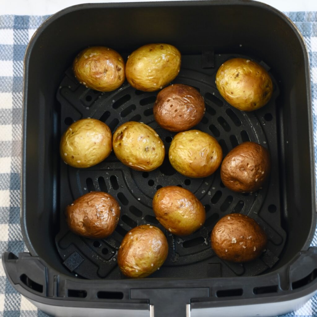 mini potatoes in an air fryer basket after cooking