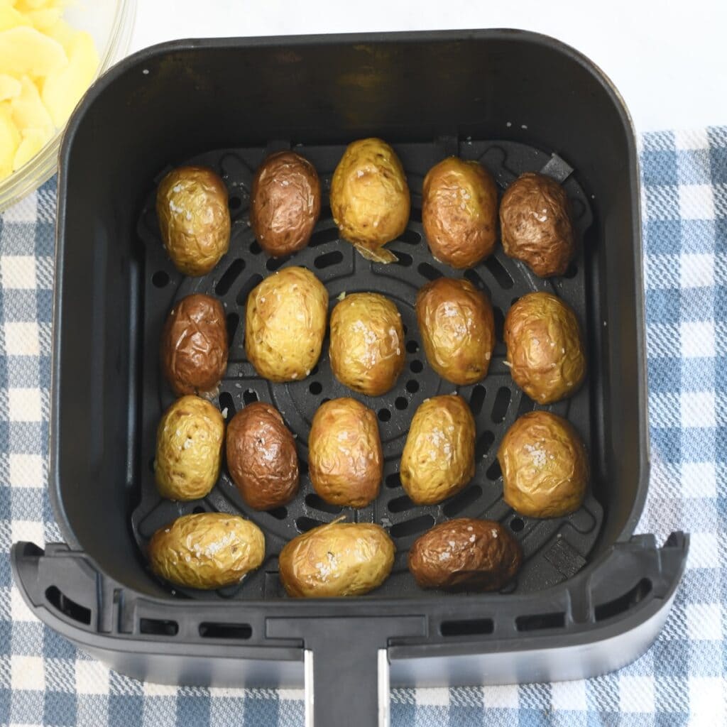 Hollowed-out mini potato skins arranged in an air fryer basket