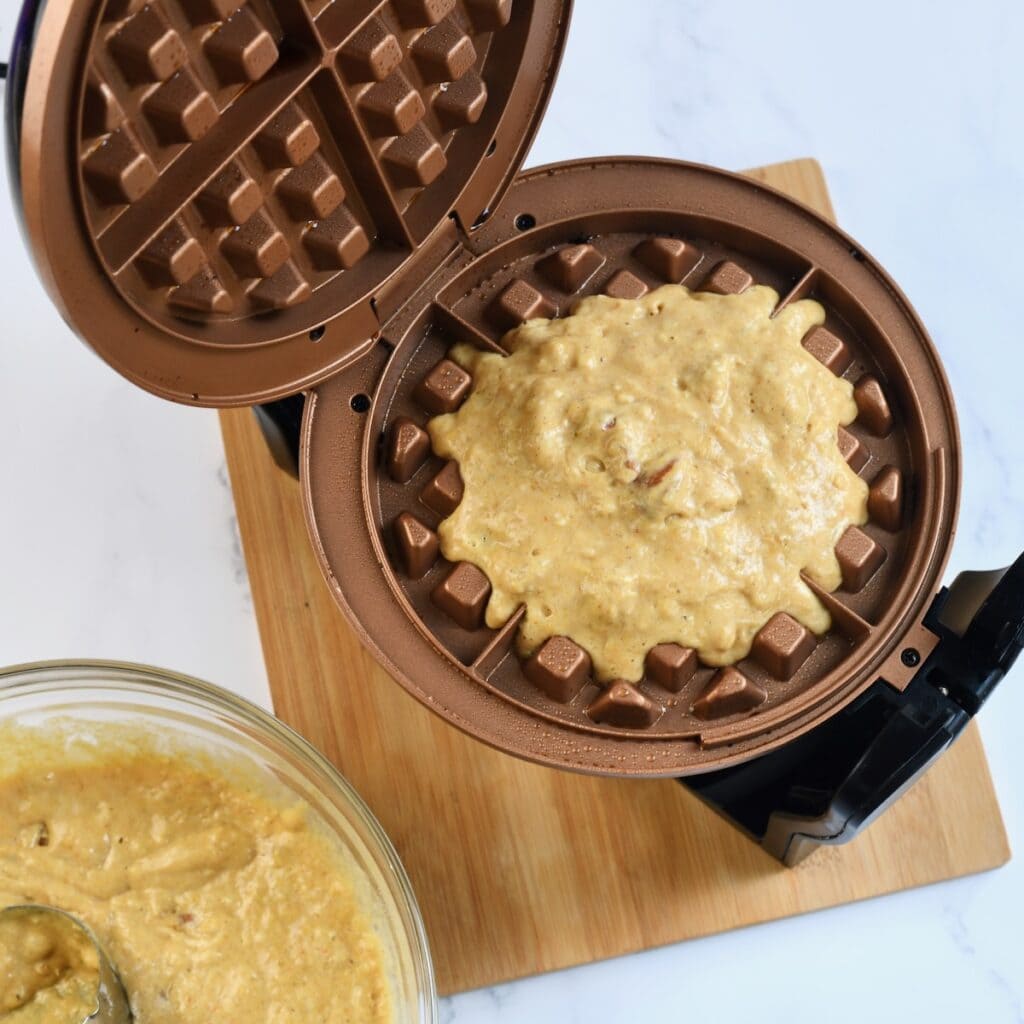 Pumpkin Pecan Waffle batter in a belgian waffle maker.