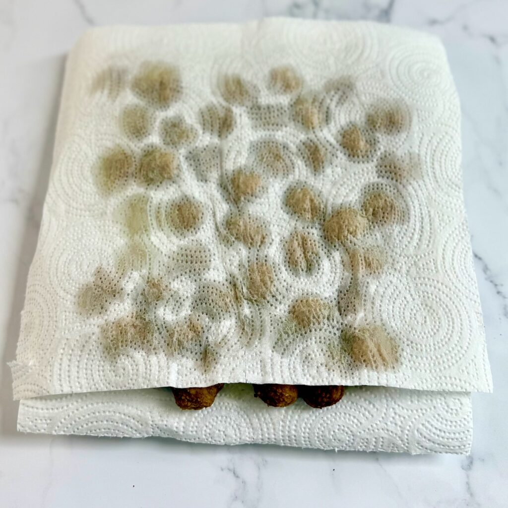 Meatballs in a layer of paper towels after being microwaved.