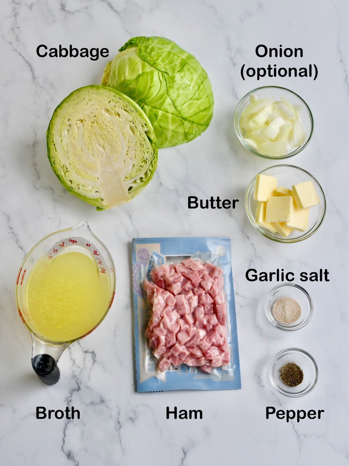 Ingredients for crock pot cabbage and ham. L-R: cabbage, broth, cubed ham, onion, butter, garlic salt, pepper.