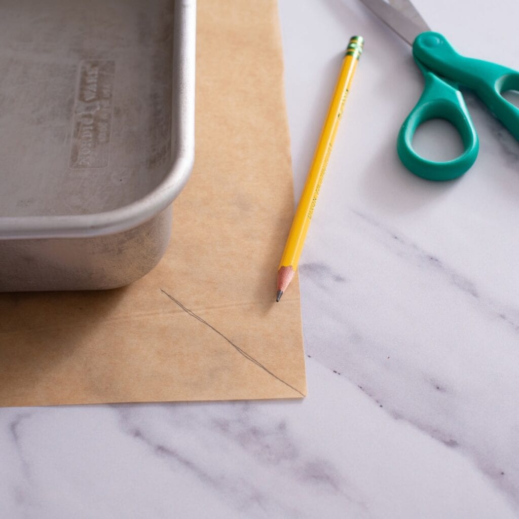 Parchment paper underneath the baking pan, to show how to measure and cut the parchment paper.