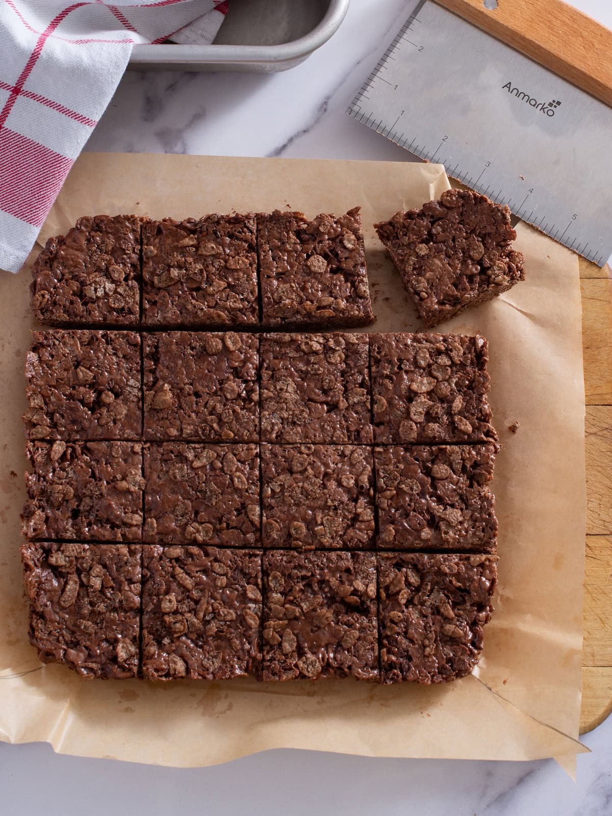 Chocolate rice krispie bars on a piece of parchment paper sliced into squares.