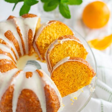 Overhead image of orange poppy seed cake with three slices shingled.