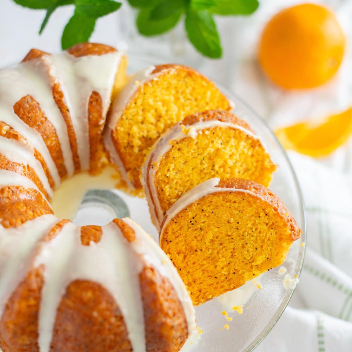 Overhead image of orange poppy seed cake with three slices shingled.
