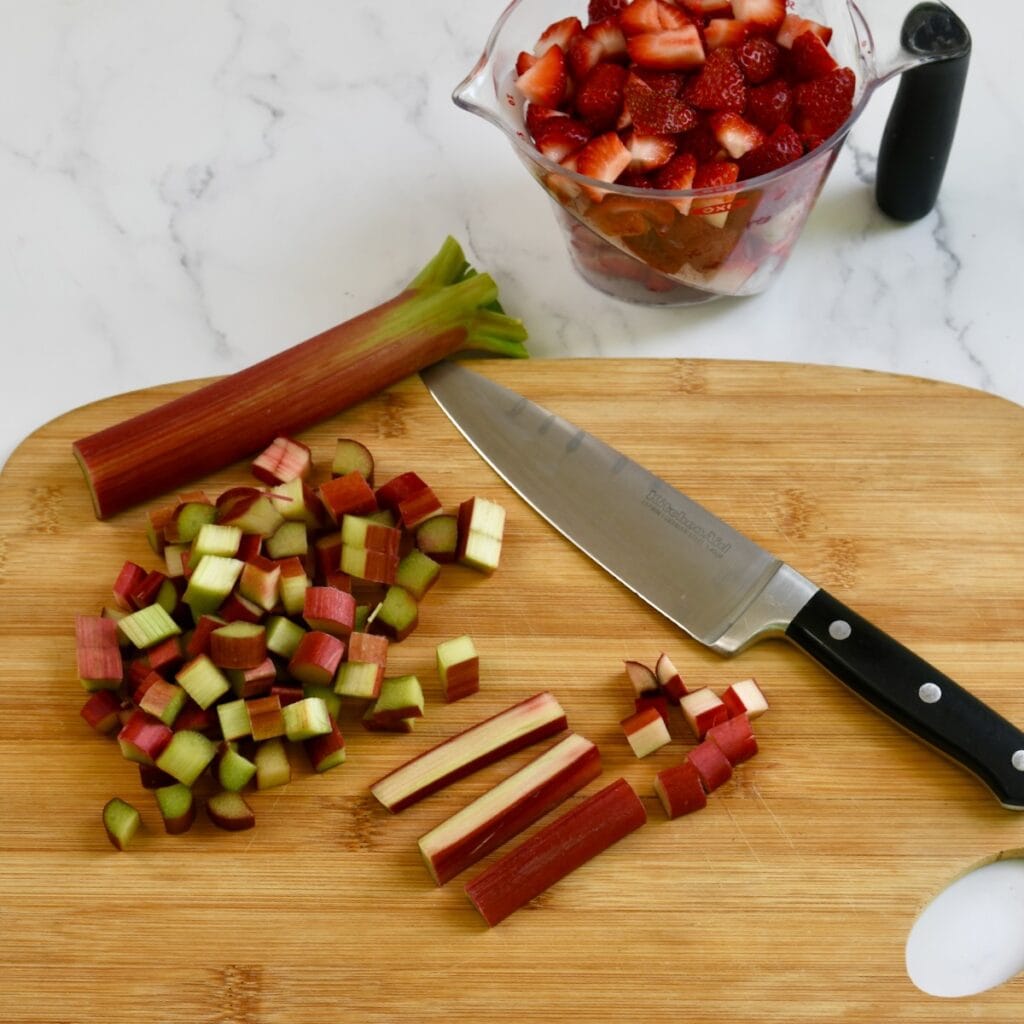 Slicing rhubarb on a wooden cutting board.