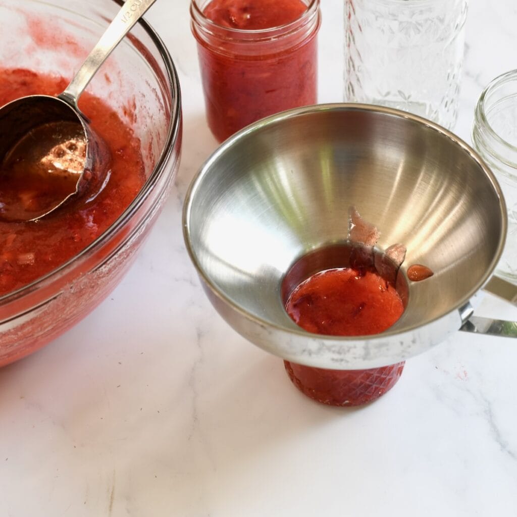 Pouring the finished jam into the prepared jar.