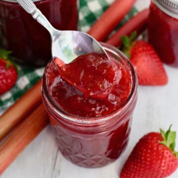 Spoon in the small jar of strawberry rhubarb jam with jello.
