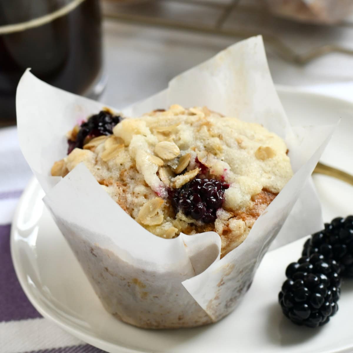 Banana blackberry muffin wrapped in a bakery-style muffin wrapper.