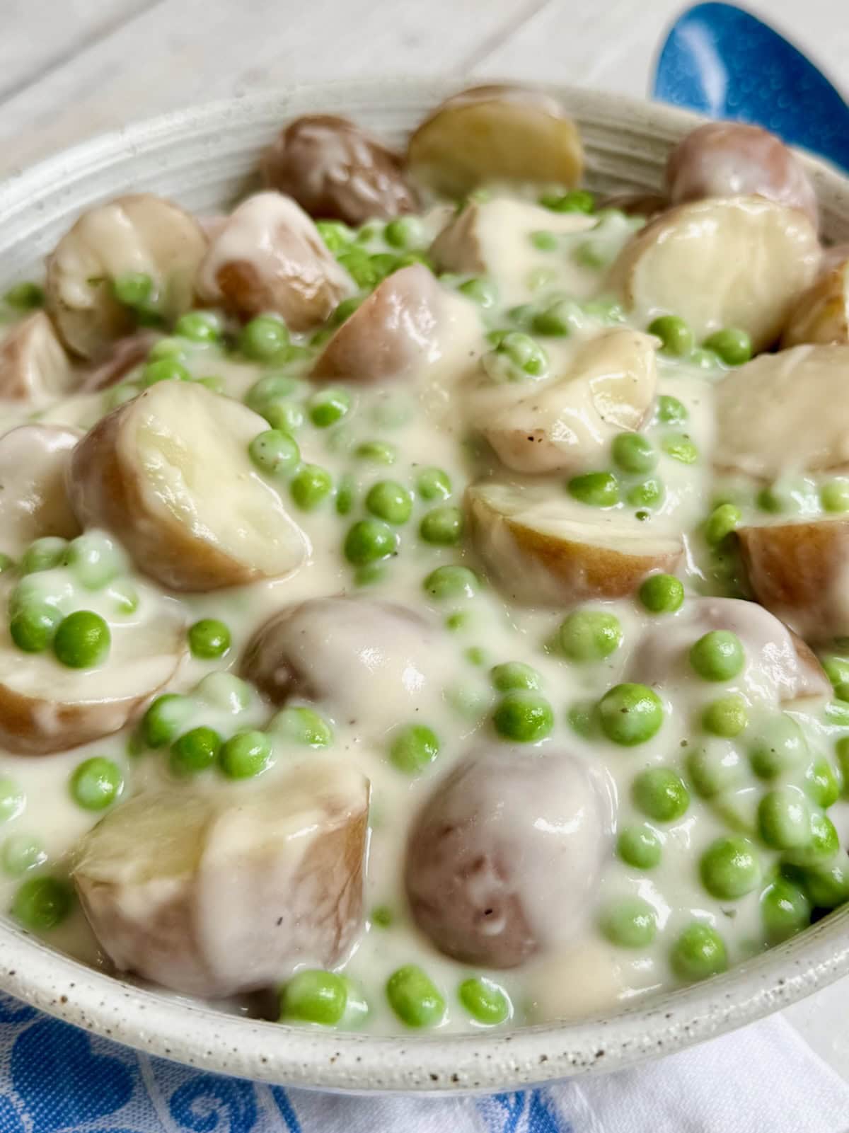 Creamed peas and potatoes in a serving bowl.