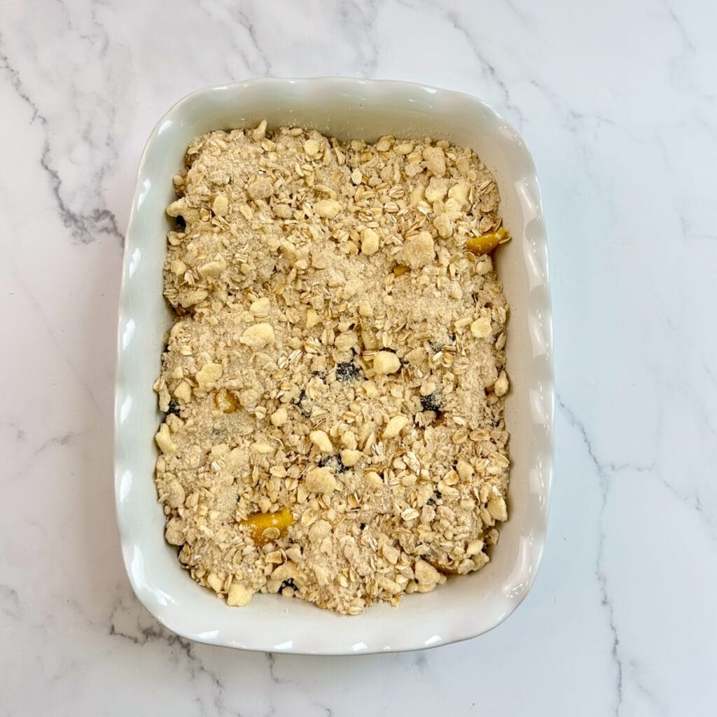 Cobbler topping placed on top of the peach and blueberry mixture in a baking dish.