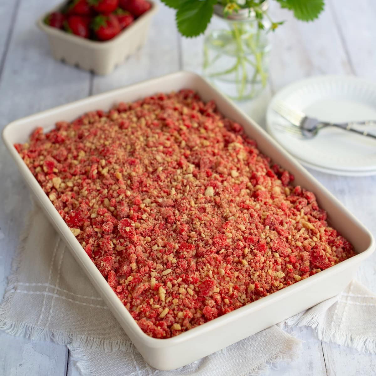 Finished strawberry crunch cake in a white baking dish.