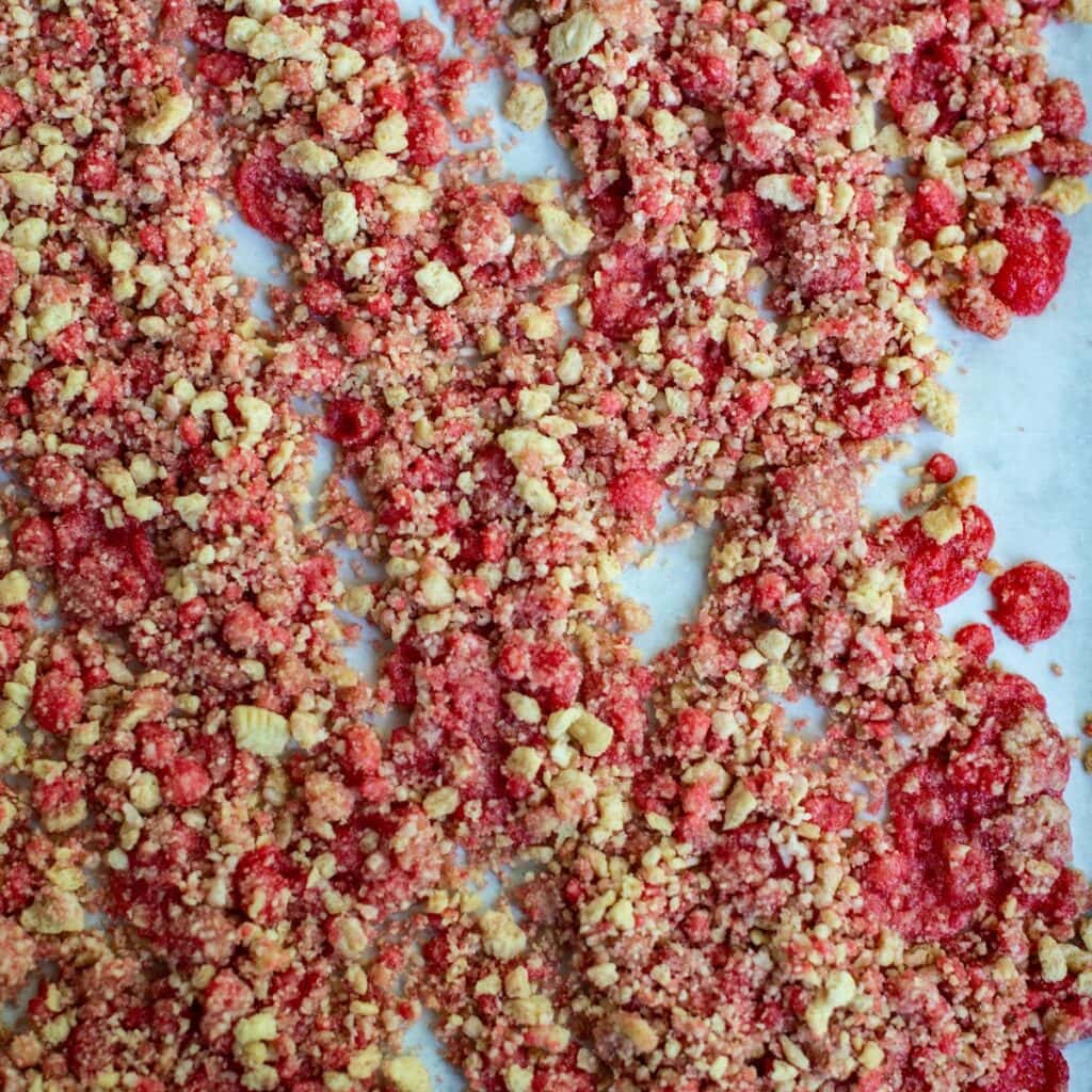 Strawberry crunch layer spread out on a sheet pan.