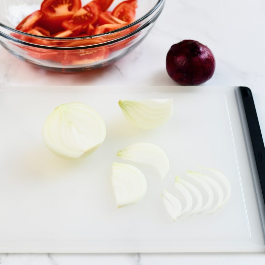 Sliced white onion on a cutting board.