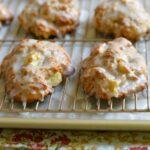 Baked apple fritters on a wire rack to set the glaze.