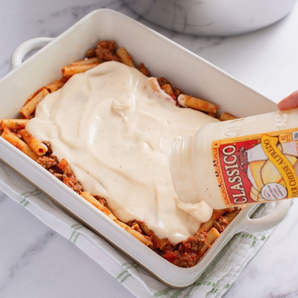 Alfredo sauce layered on top of the pasta with meat sauce.