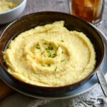 Gouda grits served in a shallow bowl, garnished with chives.