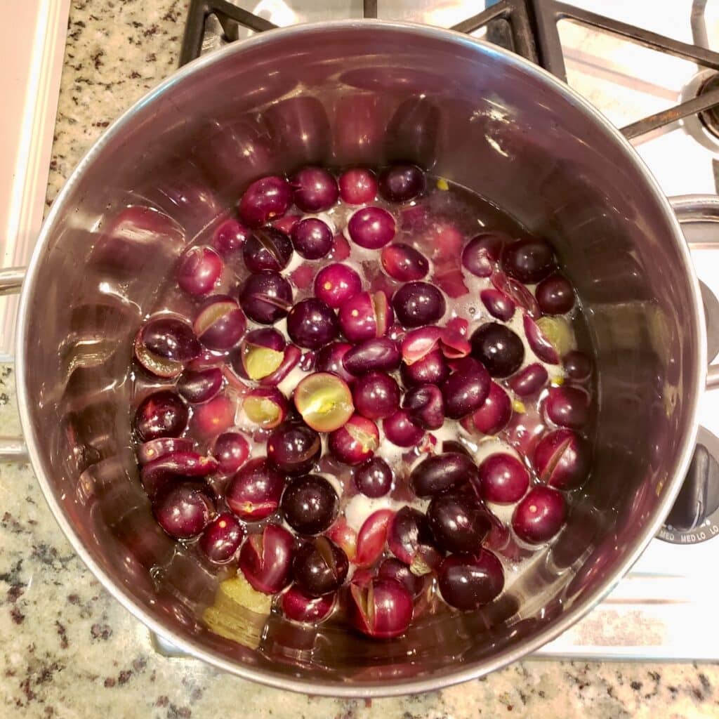 Muscadine grapes in a pot with water to cook.