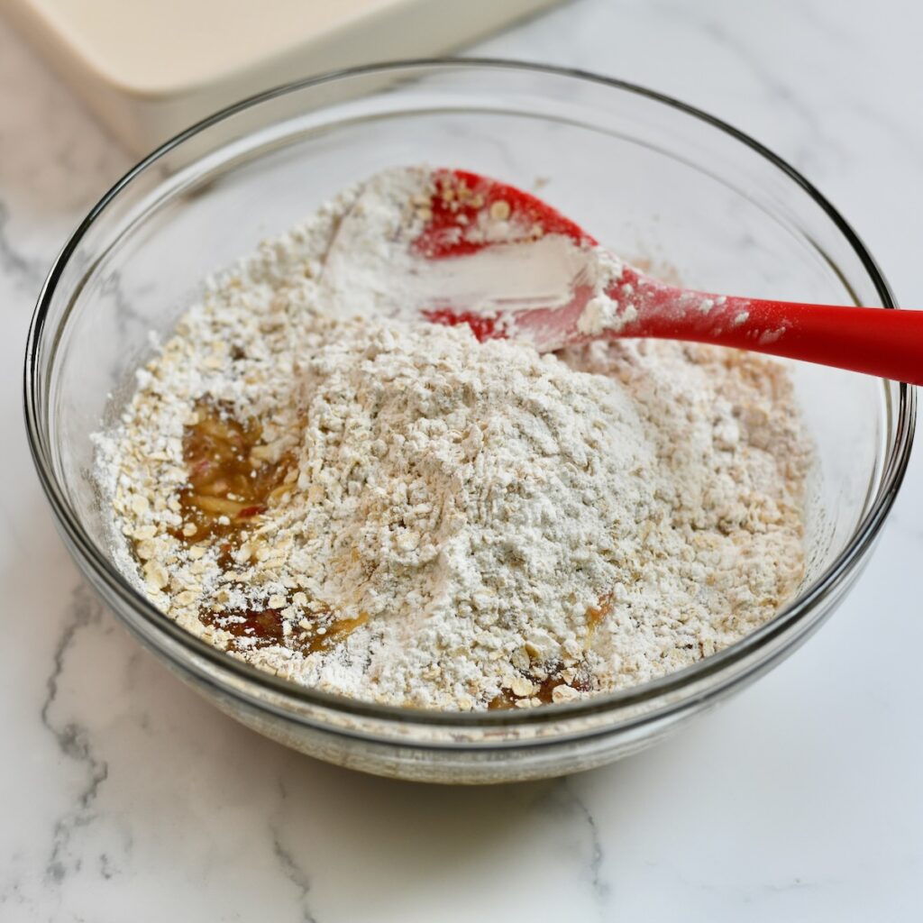 Mixing together the apple oatmeal cake batter in a bowl.