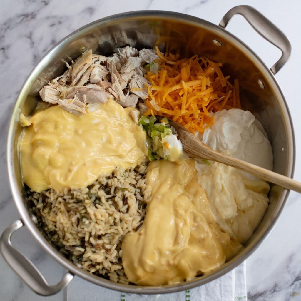 Chicken wild rice casserole ingredients all placed in a pot to mix together.