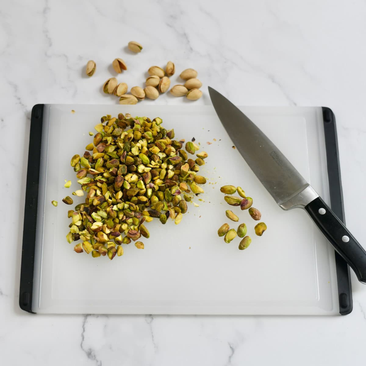 Chopping pistachios on a cutting board.