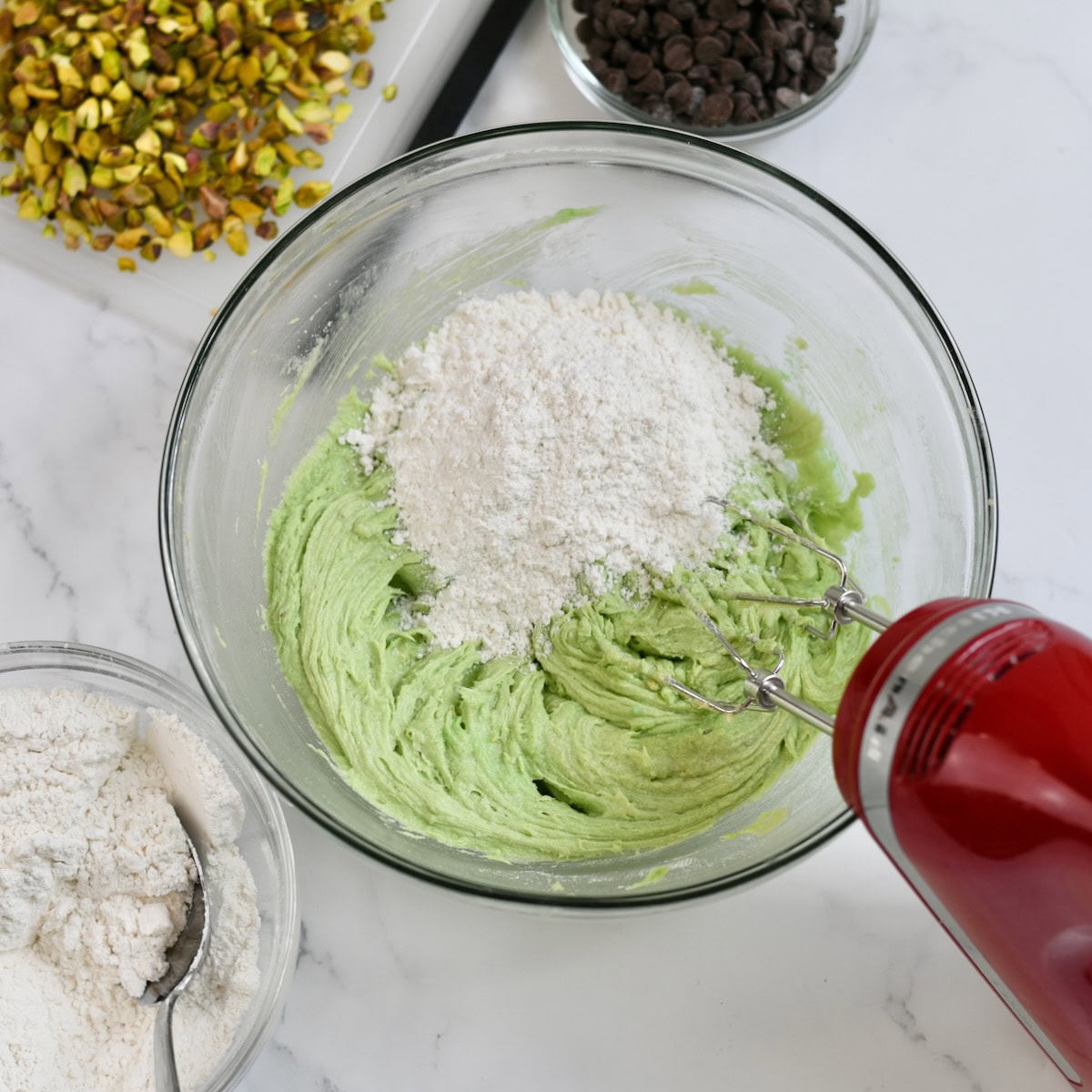 Adding flour to the pistachio cookie dough.