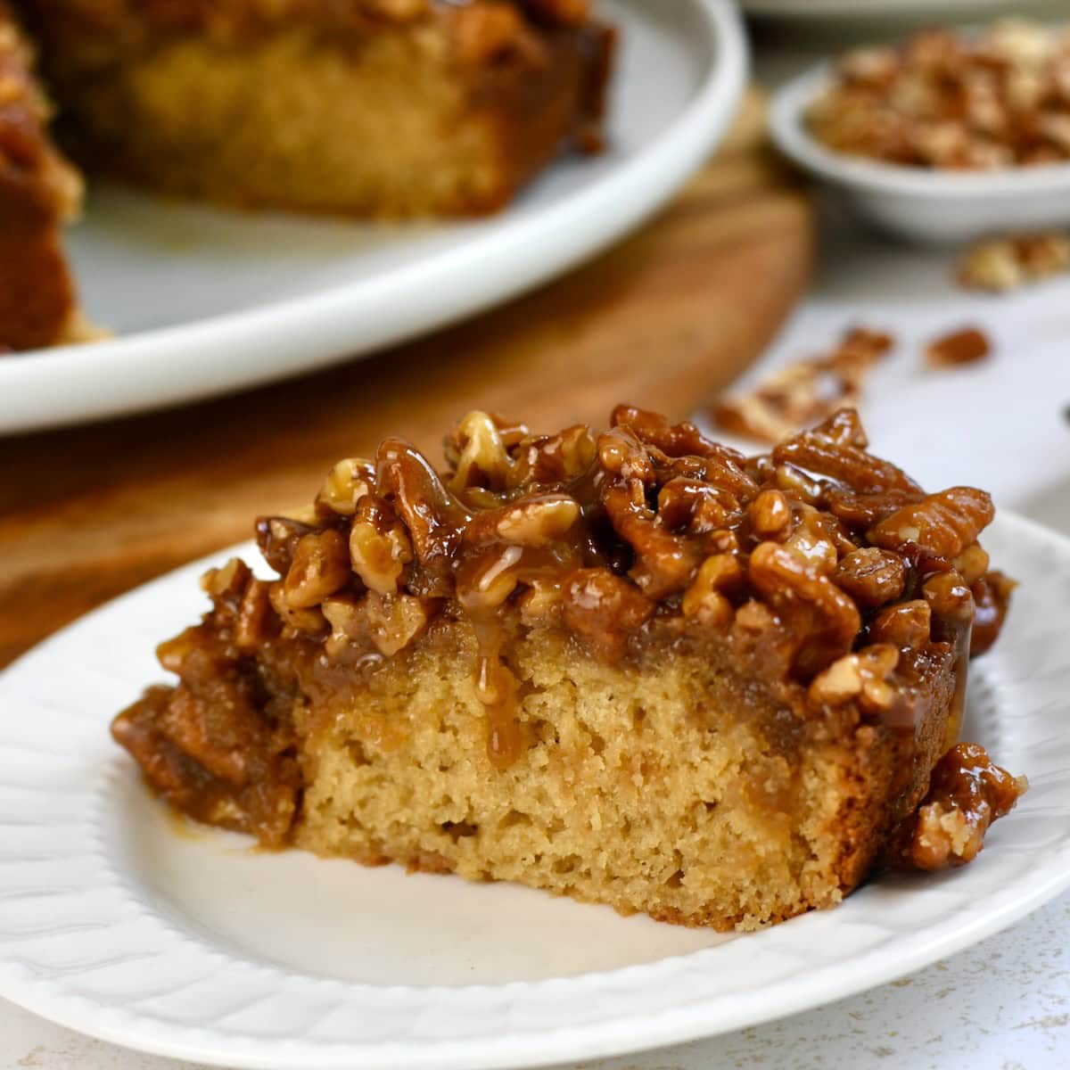 Side view of a slice of pecan upside down cake.