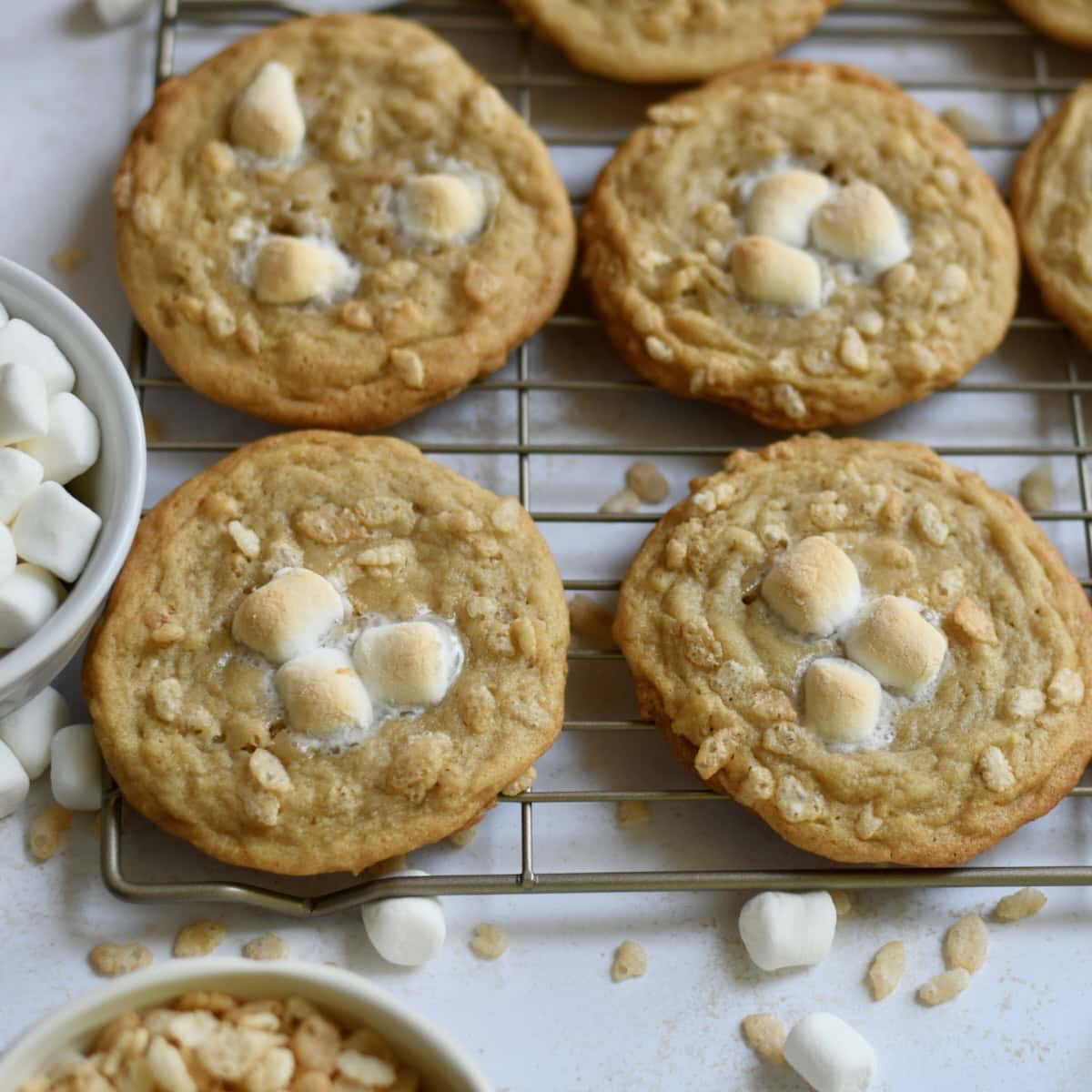 Rice krispie cookies on a cooling rack with mini marshmallows on top.